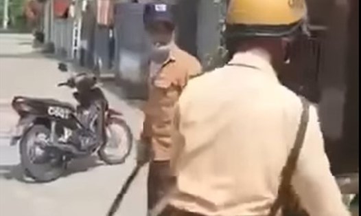 Thanh niên không đội mũ bảo hiểm còn cầm dao dọa chém cảnh sát giao thông làm nhiệm vụ. Ảnh cắt từ clip.