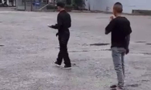 Hai người mặc đồ đen được cho là có hành vi hành hung chủ xe tại trung tâm đăng kiểm ở Thái Bình. Ảnh cắt từ clip.