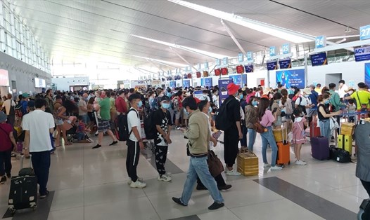 Du khách làm thủ tục ở sân bay Phú Quốc tuân thủ quy định phòng dịch COVID-19. Ảnh: PV