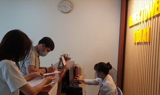 Người dân khai báo y tế trực tiếp tại sảnh tòa nhà Gemek Tower (Hà Nội) khi trở về thành phố sau kỳ nghỉ lễ. Ảnh: PV