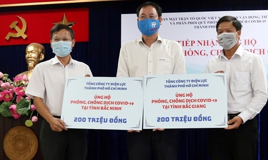 Ông Lê Văn Minh (bên phải) và ông Phạm Việt Anh – Phó Ban Truyền thông (trái) đại diện EVNHCMC trao 400 triệu đồng ủng hộ 2 tỉnh Bắc Giang, Bắc Ninh phòng chống COVID-19. Ảnh EVNHCMC cung cấp.