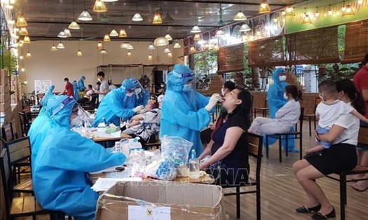 Nhân viên y tế lấy mẫu dịch hầu họng cho người dân ở khu đô thị Đồng Sơn, thành phố Phúc Yên, Vĩnh Phúc. Ảnh: TTXVN