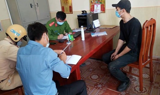 Công an huyện Tiền Hải (Thái Bình) lập biên bản xử phạt các trường hợp không đeo khẩu trang nơi công cộng. Ảnh: Hường Nguyễn