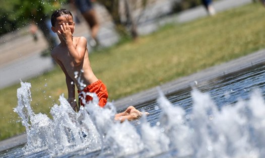 Một bé trai tắm tại một đài phun nước công cộng ở Nantes, miền tây nước Pháp trong đợt nắng nóng năm 2017. Ảnh: AFP
