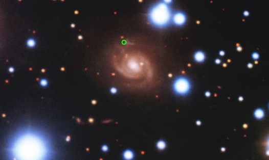 Một chớp sóng vô tuyến nhanh (vị trí màu xanh lá) do kính thiên văn CHIME phát hiện được xác định đến từ nhánh xoắn ốc của thiên hà màu đỏ ở trung tâm bức ảnh. Ảnh: CHIME