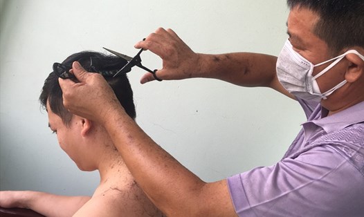 Các bác sĩ, nhân viên y tế giúp nhau cắt tóc trong Bệnh viện dã chiến huyện Yên Dũng. Việc cắt tóc gọn gàng giúp đảm bảo an toàn trong quá trình điều trị cho bệnh nhân COVID-19. Ảnh: BS Trần Đức Hà