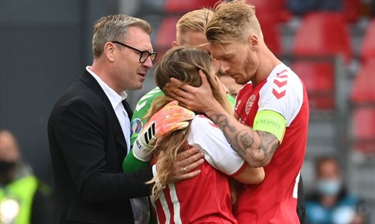 Đội trưởng Simon Kjaer cùng thành viên đội tuyển Đan Mạch trấn an vợ của Christian Eriksen trong giây phút hoảng sợ nhất đối với cô. Ảnh: AFP