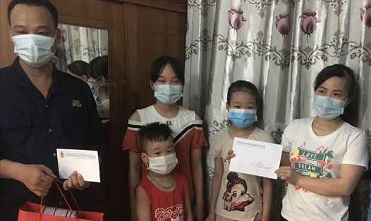 Anh Việt và gia đình xúc động nhận hỗ trợ từ tổ chức Công đoàn. Ảnh: Hải Anh
