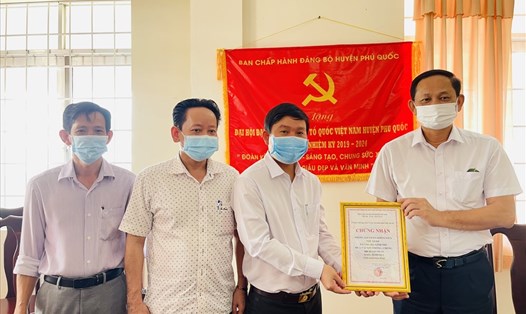 Ông Nguyễn Văn Đông An, Uỷ ban Mặt trận Tổ quốc Việt Nam thành phố Phú Quốc trao chứng nhận đến mạnh thường quân tham gia ủng hộ Quỹ Vaccine COVID-19. Ảnh: Hoàng Dung