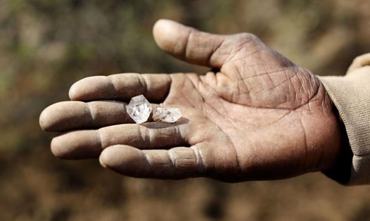Một cậu bé cầm những viên đá mà cậu tin là viên kim cương ở làng KwaHlathi gần Ladysmith, Nam Phi. Ảnh: AFP