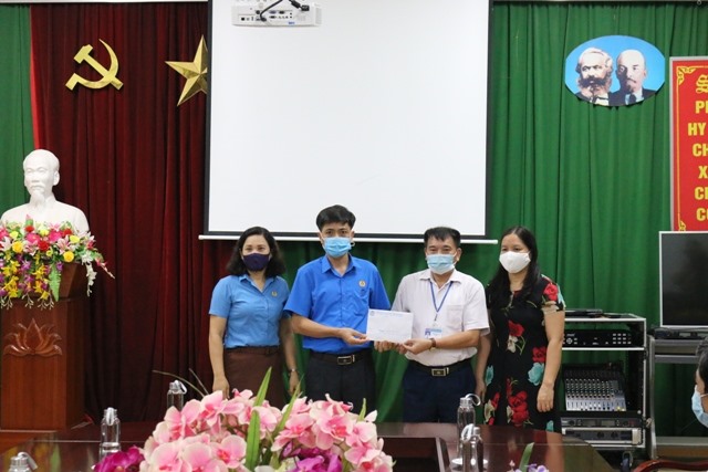 Ông Trần Văn Minh - Phó Chủ tịch thường trực Liên đoàn Lao động tỉnh trao hỗ trợ tập thể cán bộ, y bác sĩ Trung tâm kiểm soát bệnh tỉnh Hà Giang với số tiền 20 triệu đồng. Ảnh: Đức Trí
