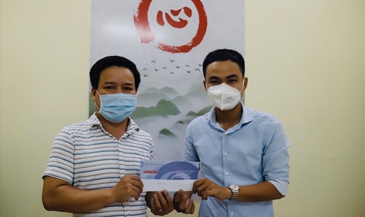 Ông Hoàng Đức Bảo (trái), Chủ tịch Hội đồng quản trị Công ty Vinabook trao 1 triệu đồng ủng hộ chương trình "Triệu liều vaccine cho công nhân nghèo". Ảnh: Tường Minh