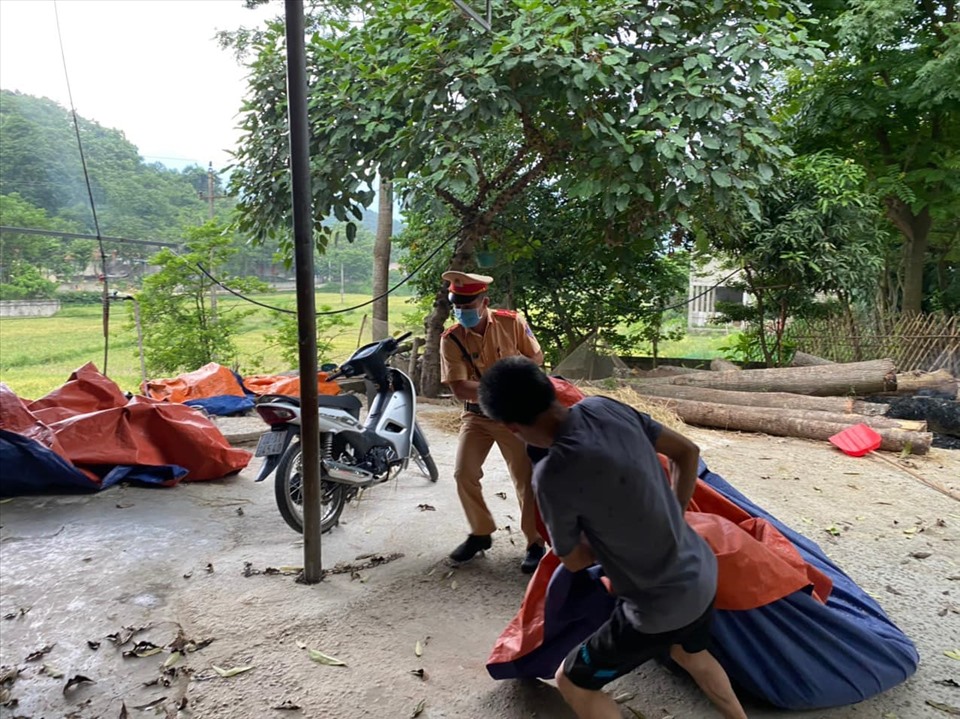 Nhờ có sự giúp sức của các chiến sĩ CSGT Tuyên Quang mà mẻ lúa đầu mùa không bị nước mưa. Ảnh: ĐVCC.