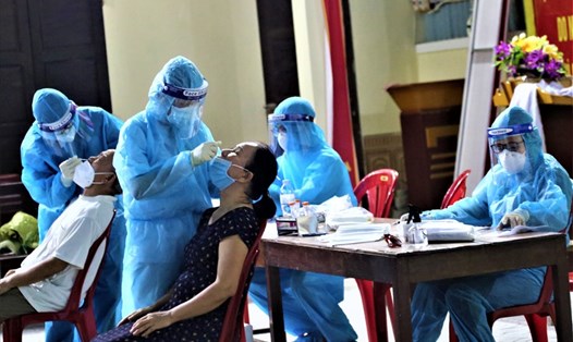 Cán bộ y tế Nghệ An lấy mẫu xét nghiệm tầm soát virus SARS-CoV-2 trên địa bàn TP. Vinh. Ảnh: Trần Duy Ngoãn