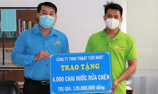 Ông Nguyễn Văn Hải (bên trái), Chủ tịch LĐLĐ Quận Bình Tân, nhận biểu trưng 4.000 chai nước rửa chén do Công ty TNHH TM&ĐT Tươi Mart ủng hộ để trao tặng cho đoàn viên công đoàn, công nhân lao động. Ảnh LĐLĐ Bình Tân