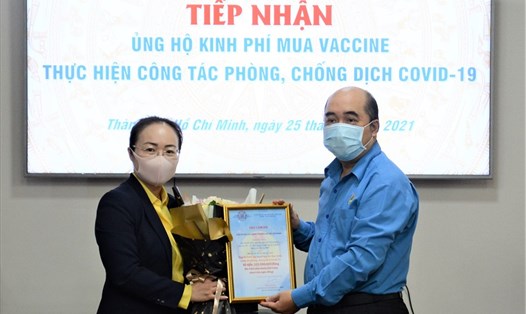 Phó Chủ tịch LĐLĐ TPHCM Hồ Xuân Lâm (bên phải) tiếp nhận biểu trưng số tiền do tập thể người lao động của Ngân hàng Nam Á ủng hộ mua vaccine phòng, chống dịch COVID-19. Ảnh LĐLĐ TPHCM