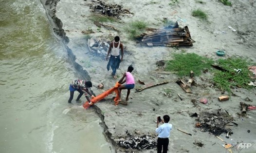 Lũ lụt trên sông Hằng rửa trôi lớp cát làm lộ diện hàng trăm thi thể chôn vùi bên bờ sông. Ảnh: AFP