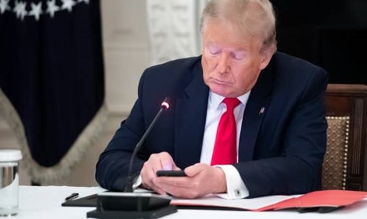Ông Donald Trump sử dụng điện thoại trong một cuộc họp tại Nhà Trắng năm 2020. Ảnh: AFP