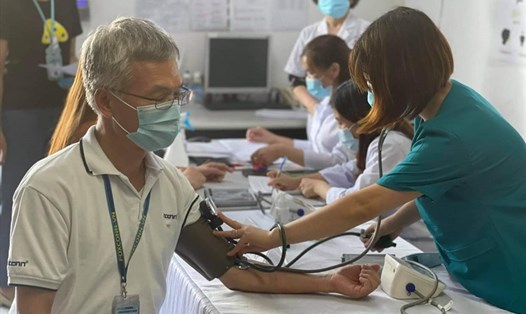 Kiểm tra sức khỏe cho công nhân trước khi tiêm phòng COVID-19 tại Bắc Giang. Ảnh: Bộ Y tế