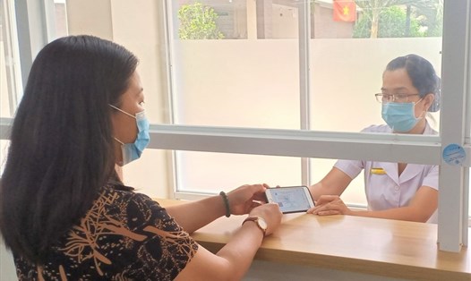 Người dân sử dụng điện thoại thông minh thay thẻ BHYT khi khám, chữa bệnh tại Bệnh viện Lê Văn Thịnh, TPHCM. Ảnh Đức Long