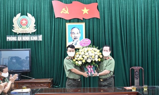Đại tá Phạm Văn Sơn, Giám đốc Công an tỉnh Ninh Bình (bên phải) tặng hoa và biểu dương hành động dũng cảm của Thiếu tá Nguyễn Văn Chung. Ảnh: NT