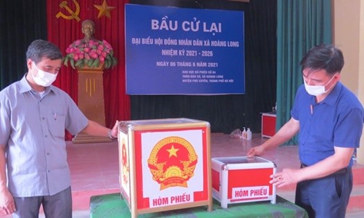 Cán bộ Ủy ban Bầu cử xã Hoàng Long kiểm tra hòm phiếu lần cuối trước ngày diễn ra bầu cử lại tại tổ bầu cử số 4, thôn Đào Xá. Ảnh Công Tâm
