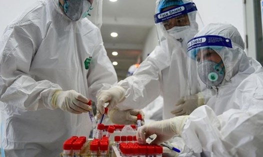 Nhân viên y tế lấy mẫu xét nghiệm COVID-19 ở Hà Nội. Ảnh: AFP