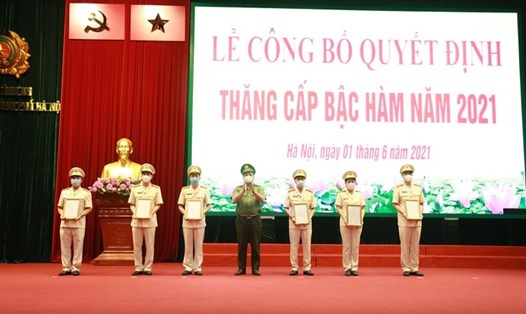 Trung tướng Nguyễn Hải Trung trao quyết định thăng cấp bậc hàm từ Trung tá lên Thượng tá cho Phó trưởng các đơn vị, Công an các quận, huyện. Ảnh: CAHN