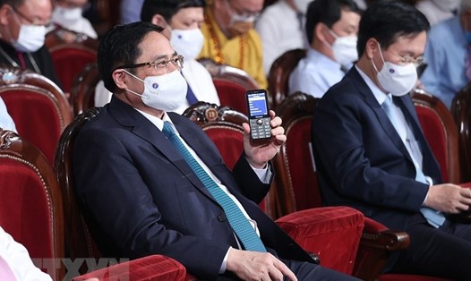 Thủ tướng Phạm Minh Chính và các đại biểu nhắn tin ủng hộ Quỹ vaccine. Ảnh: TTXVN