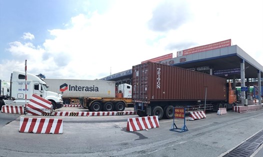Xe container xếp hàng dài chờ qua cổng B cảng Tân Cảng - Cát Lái để lấy, xuất hàng hóa.   Ảnh: Anh Tú