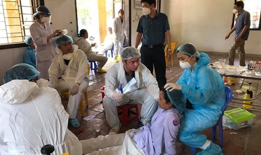 Hỗ trợ nhân viên y tế bị kiệt sức do làm việc quá sức ở Bắc Ninh hồi cuối tháng 5. Ảnh: Văn Chương