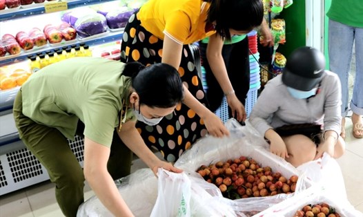 Cán bộ Cục QLTT Quảng Bình hỗ trợ tiêu thụ vải thiều Bắc Giang tại các siêu thị. Ảnh: Lê Phi Long