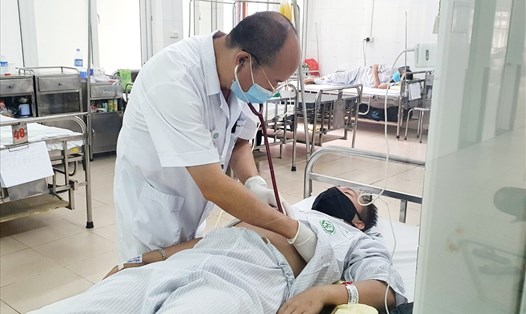 PGS.TS Đỗ Duy Cường thăm khám cho bệnh nhân tại Trung tâm bệnh nhiệt đới, Bệnh viện Bạch Mai. Ảnh: BVCC