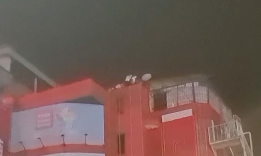 Nhiều người bất chấp nguy hiểm lên sân thượng để trèo sang nhà khác khi cảnh sát kiểm tra quán karaoke không phép. Ảnh: cắt từ clip