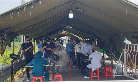 Người dân xếp hàng làm thủ tục vào Quảng Ninh tại Chốt kiểm soát dịch Trạm thu phí cầu Bạch Đằng. Ảnh: Nguyễn Hùng