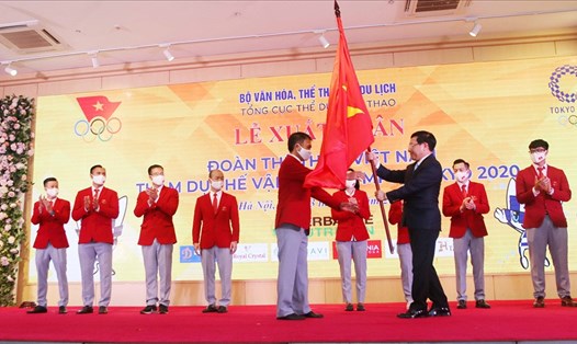 Trưởng đoàn Trần Đức Phấn nhận cờ từ Phó Thủ tướng Phạm Bình Minh. Ảnh: Bùi Lượng