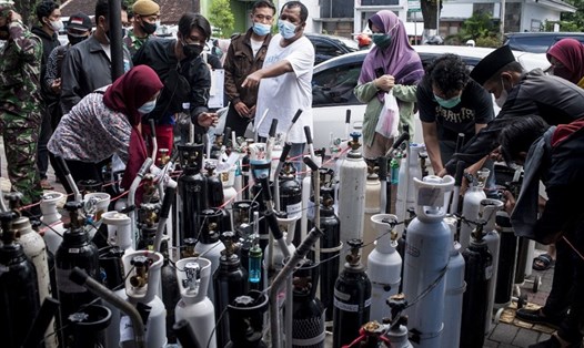 Người dân ở Indonesia tại địa điểm nạp bình ôxy. Ảnh: AFP
