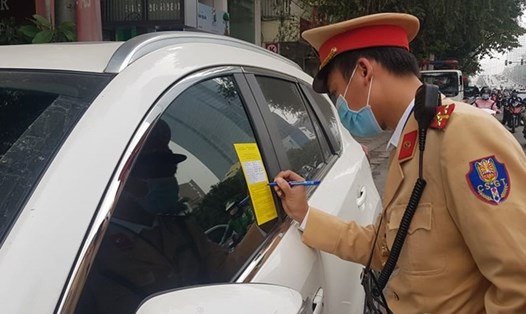 Cảnh sát giao thông Hà Nội dán giấy phạt nguội lên kính các xe ôtô dừng, đỗ sai quy định. Ảnh: V.Dũng