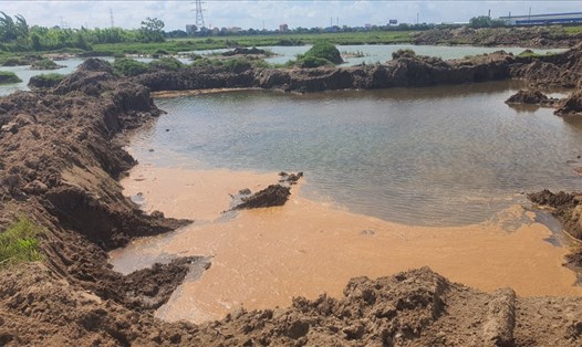 "Đất tặc" xúc đất, cát mang ra khỏi KCN Mỹ Trung (huyện Mỹ Lộc, tỉnh Nam Định) để lại những vũng nước loang lổ. Ảnh: T.D