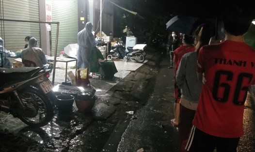 Người lao động dầm mưa xếp hàng chờ lấy mẫu xét nghiệm tầm soát COVID-19 tại thị xã Bến Cát, Bình Dương. Ảnh: Dương Bình