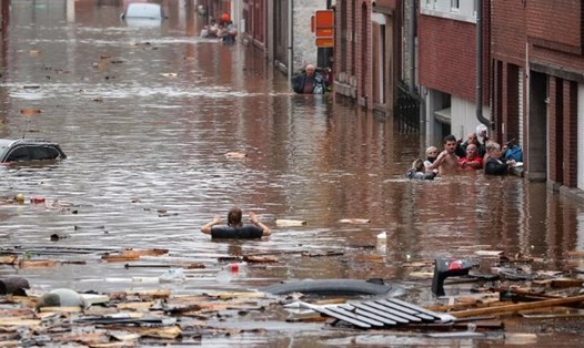 Một người phụ nữ đang di chuyển trong nước lũ ở Liege, Bỉ. Ảnh: AFP