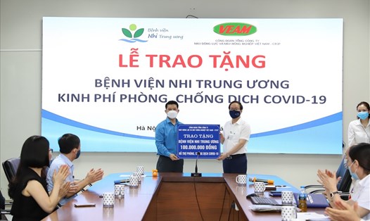Ông Mai Mạnh Dũng đại diện Công đoàn Tổng Công ty VEAM (bên trái) trao tặng kinh phí cho Bệnh viện Nhi trung ương. Ảnh: CĐV