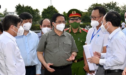 Thủ tướng nghe lực lượng chức năng báo cáo việc thực hiện Chỉ thị 16 tại phường Tân Phú, TP. Thủ Đức. Ảnh Nhật Bắc