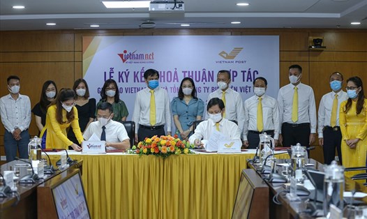 Tổng Biên tập Báo VietNamNet Phạm Anh Tuấn và Tổng Giám đốc Vietnam Post Chu Quang Hào ký thỏa thuận hợp tác.