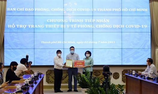 Chủ tịch UBND TPHCM Nguyễn Thành Phong (trái) và Chủ tịch Ủy ban MTTQ Việt Nam TPHCM Tô Thị Bích Châu tiếp nhận bảng tượng trưng tặng trang thiết bị y tế của một doanh nghiệp.  Ảnh: TTBC