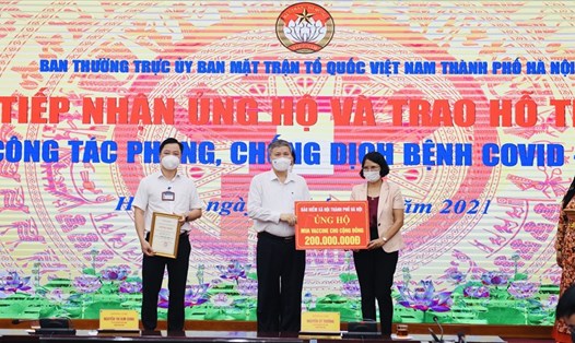 Ông Nguyễn Đức Hoà - Giám đốc BHXH thành phố Hà Nội (đứng giữa) trao 200 triệu đồng ủng hộ phòng chống dịch COVID-19. Ảnh: BHCC