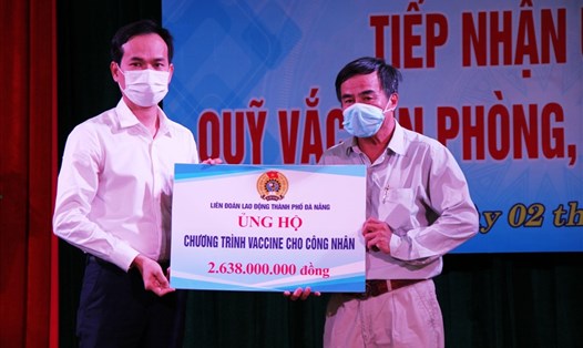 Ông Nguyễn Duy Minh (trái) trao hơn 2,6 tỉ đồng đến đại diện Quỹ Tấm lòng Vàng Lao Động để ủng hộ chương trình vaccine cho công nhân. Ảnh: Thái Bình