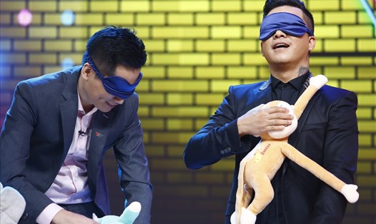 Ca sĩ Tuấn Hưng và MC Quốc Khánh có cuộc so tài trong minigame bịt mắt thay bỉm. Ảnh: VTV