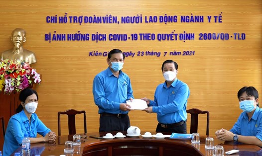 Ông Trần Thanh Việt (phải) trao hỗ trợ cho đại diện Công đoàn ngành Y tế để sau đó chuyển khoản đến các đoàn viên ngành y tế đang làm nhiệm vụ tại các cơ sở y tế, khu cách ly... Ảnh: LT