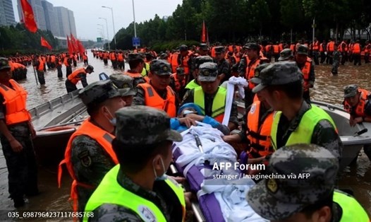 Lực lượng cứu hộ đang giúp đỡ những người dân bị mắc kẹt đến nơi an toàn. Ảnh: AFP